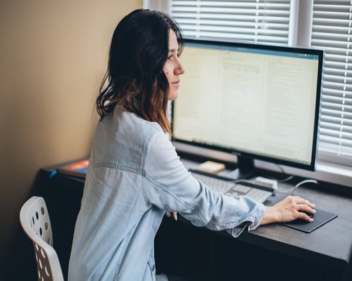 Person looking out the window away from their computer screen