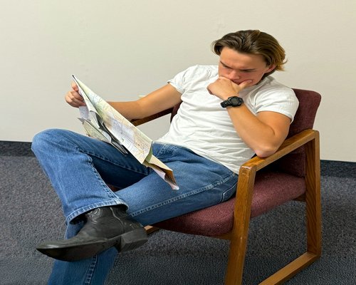 A person sitting with good posture while reading a magazine